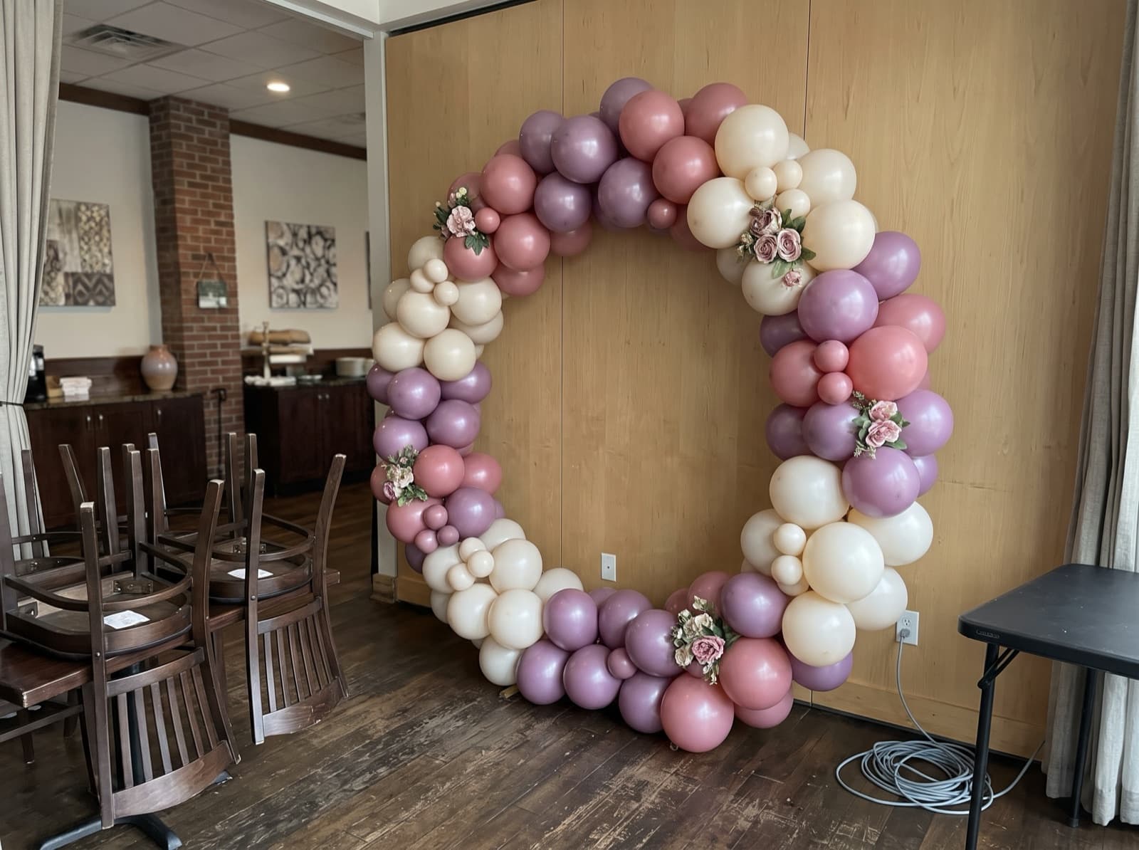 Round balloon arch in mauve and cream framing a photo spot