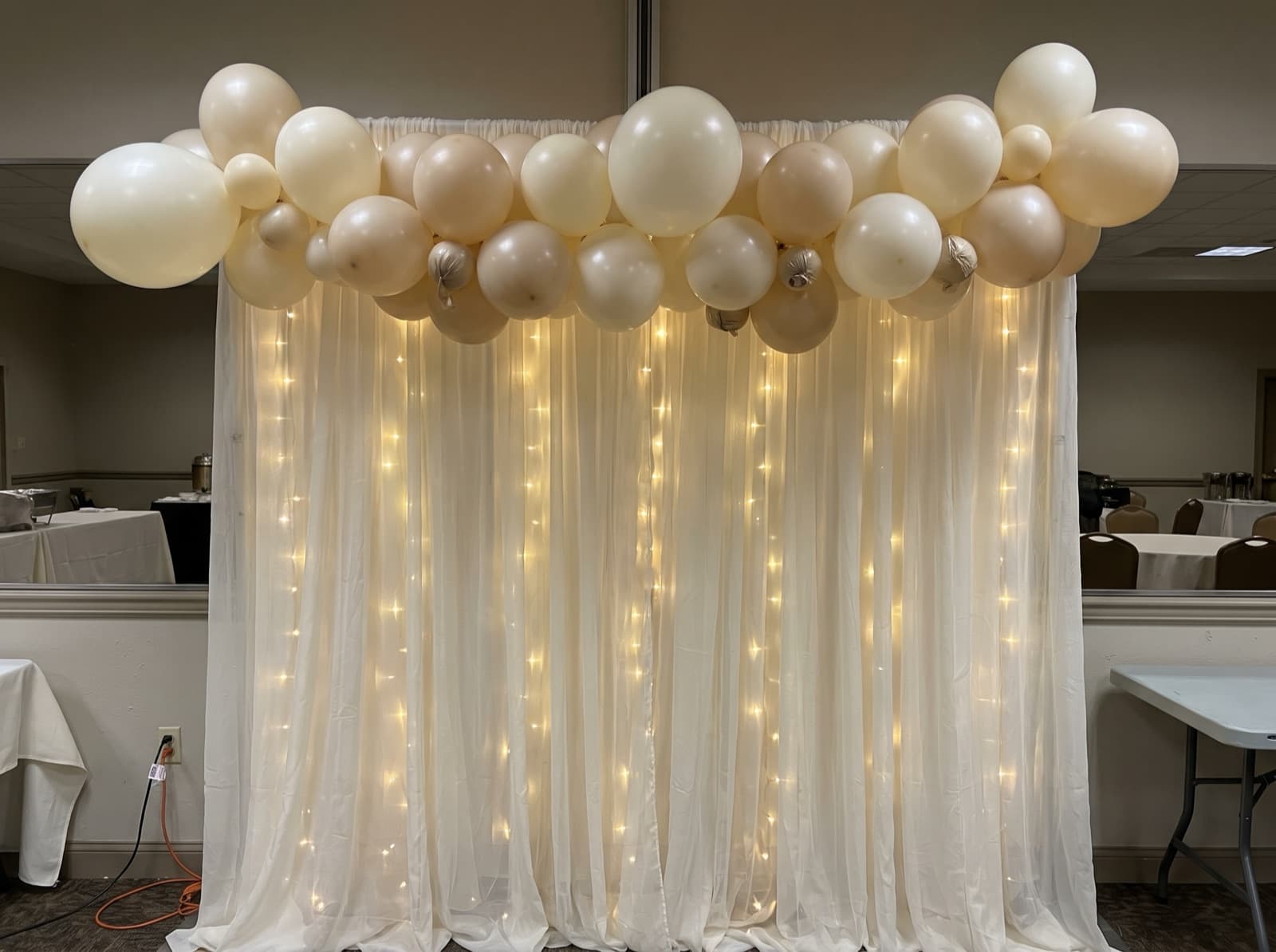 Draped backdrop with balloons and lights