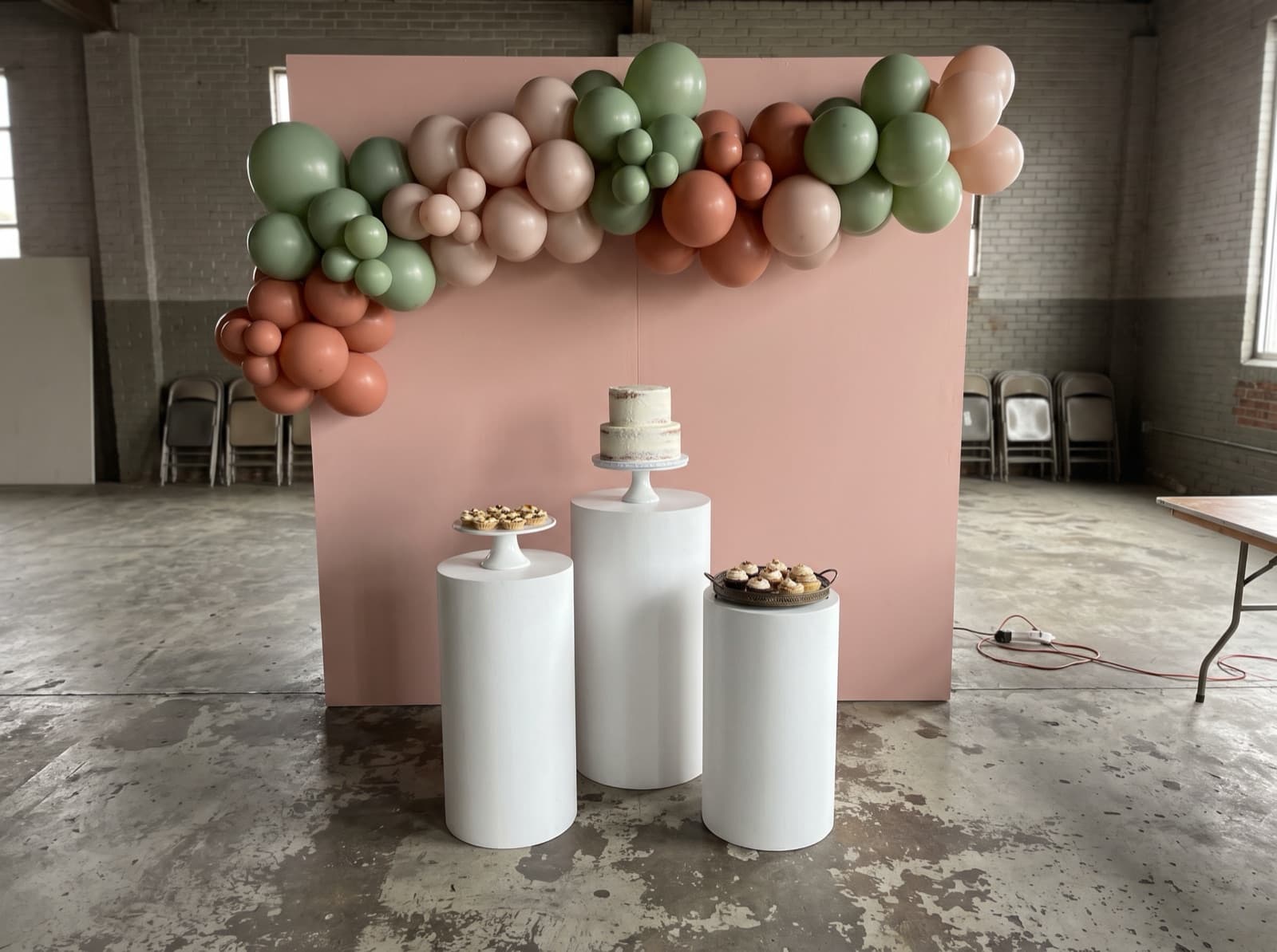 Backdrop with pedestals and a cake table