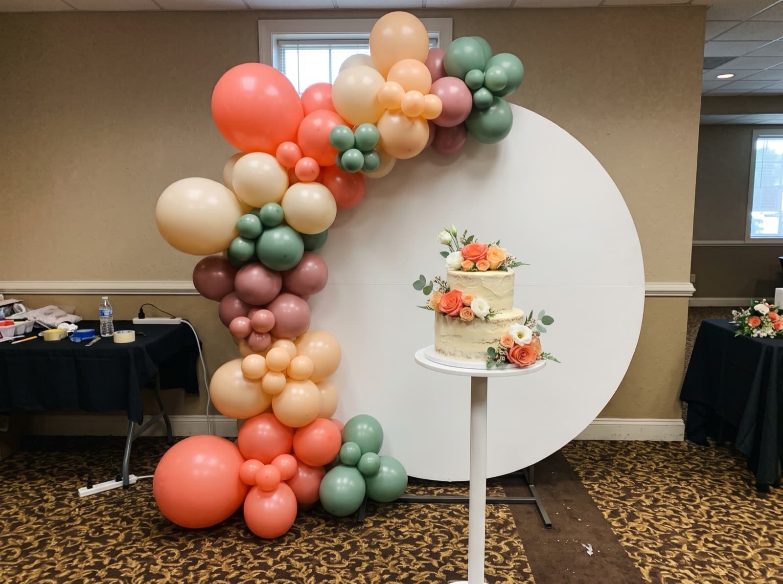 Round backdrop with a coral and peach organic garland