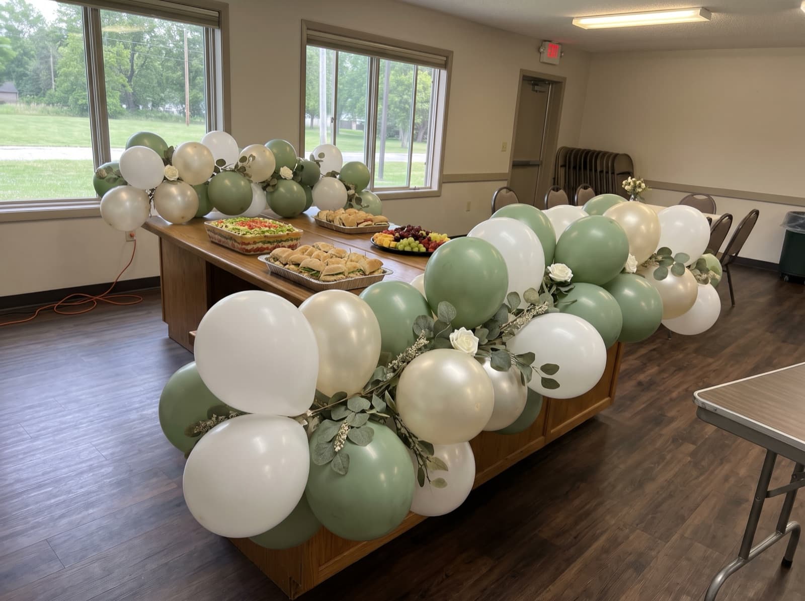 Balloon garland with greenery on a buffet table