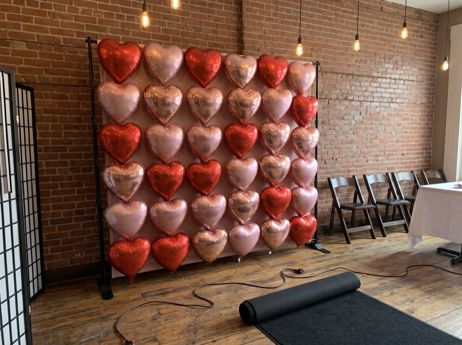 Foil heart balloon wall in red and rose gold