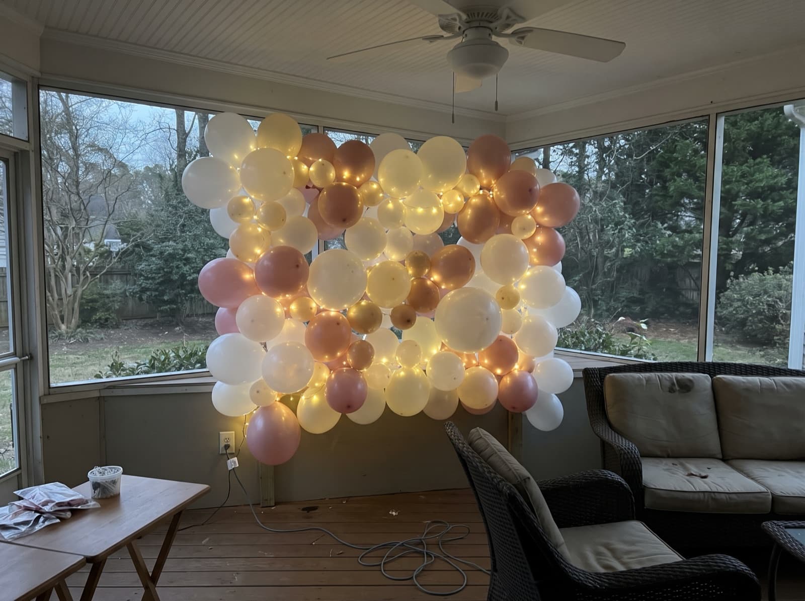 Balloon wall with string lights on a covered patio